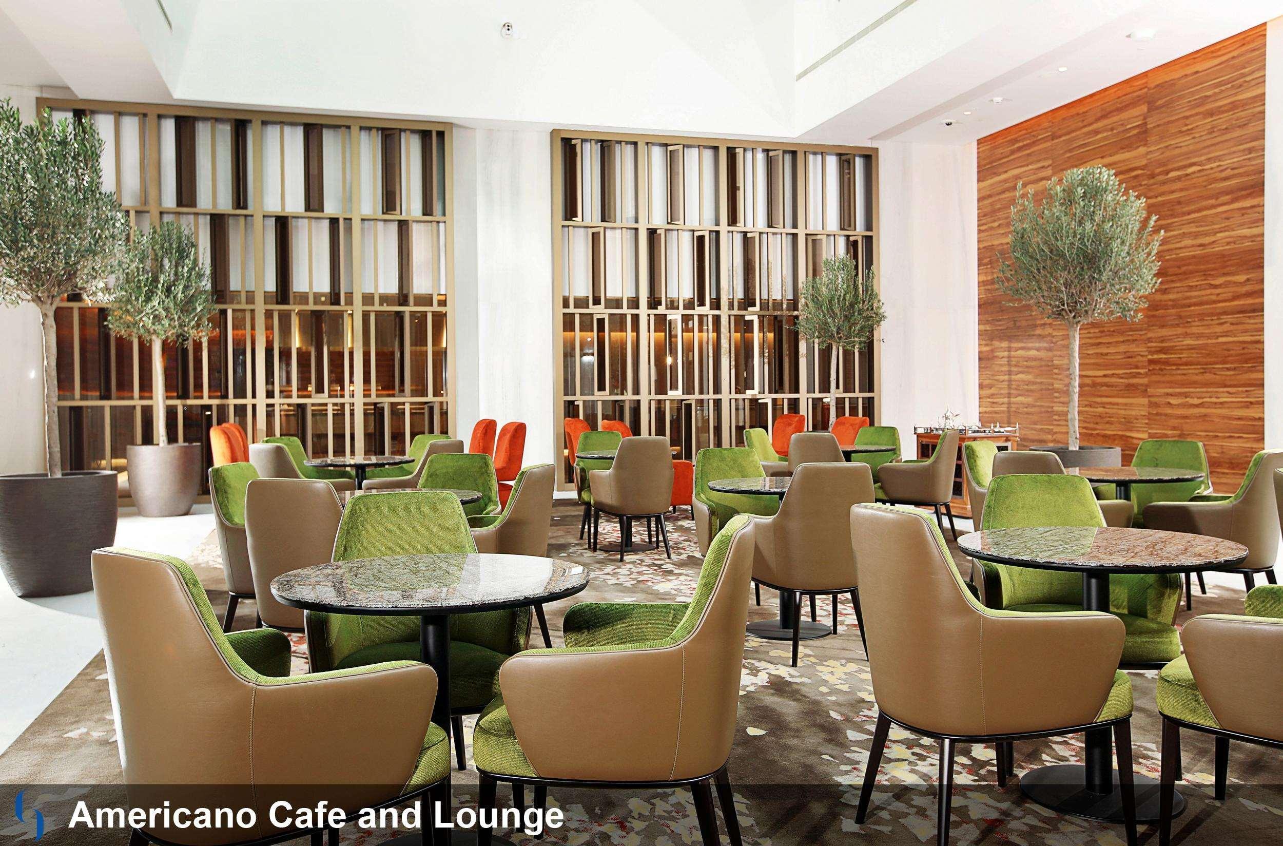 Grand Cosmopolitan Hotel Dubai Luaran gambar The photo showcases a modern cafe and lounge called "Americano Cafe and Lounge." The interior features a spacious area with various seating arrangements. There are several round tables surrounded by green and beige chairs, creating a fresh and inviti