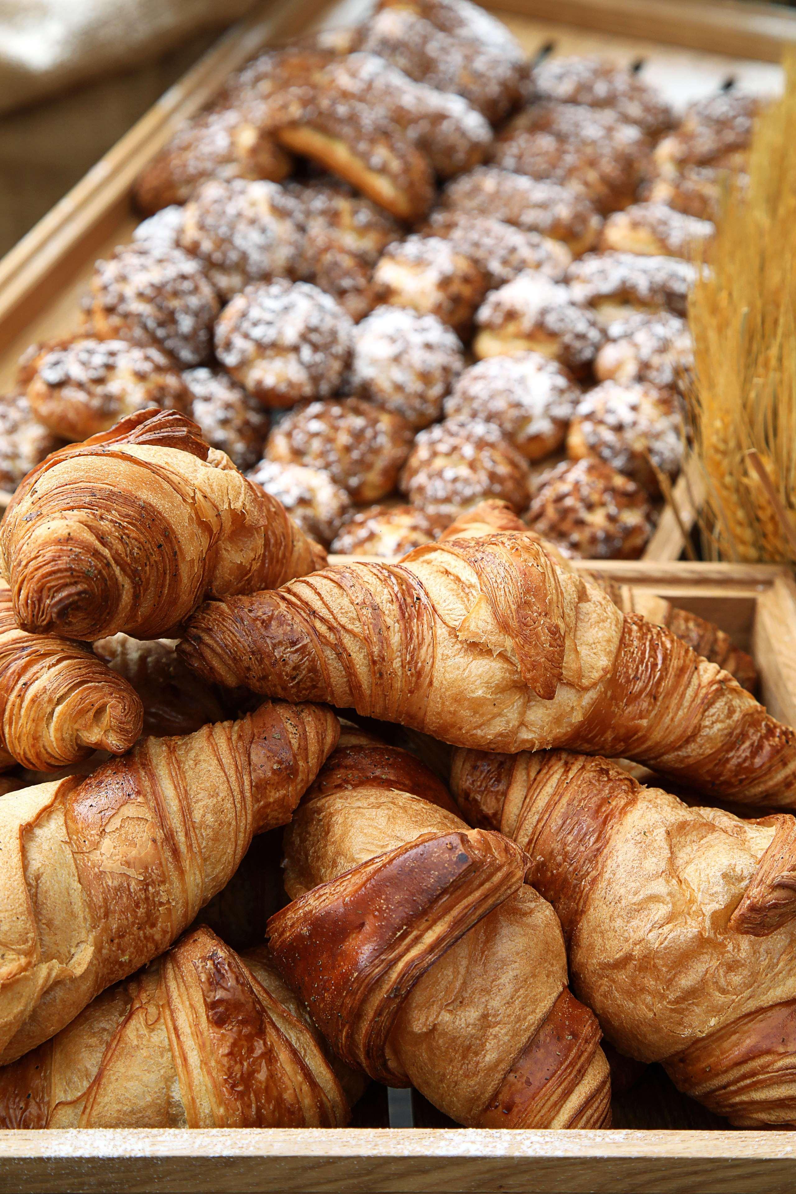 Grand Cosmopolitan Hotel Dubai Luaran gambar The photo displays a selection of baked goods, prominently featuring several golden-brown croissants. The croissants are flaky and have a distinct, spiral shape characteristic of this pastry. In the background, there are additional baked items, possi
