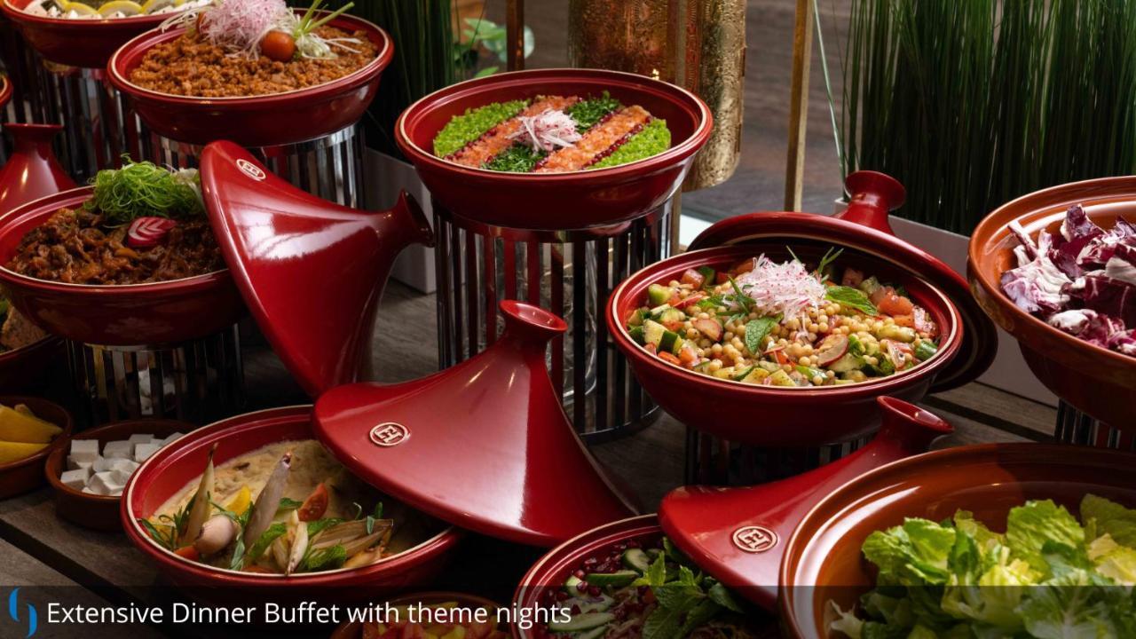 Grand Cosmopolitan Hotel Dubai Luaran gambar The photo displays an assortment of colorful dishes arranged in red ceramic containers. Each dish appears to have various ingredients, likely featuring a mix of vegetables, proteins, and grains. The presentation is visually appealing, with vibrant gr