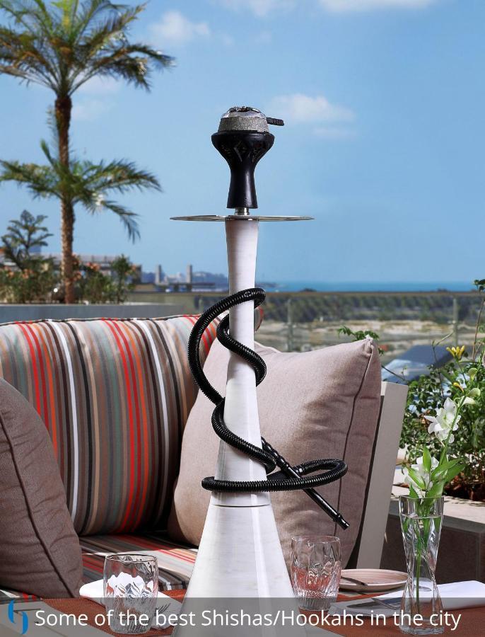 Grand Cosmopolitan Hotel Dubai Luaran gambar The photo features a hookah, also known as a water pipe, placed on a table. The hookah has a tall, slender body with a bowl at the top for placing tobacco. A flexible hose is coiled around the base of the hookah, which is connected to the main body. 
